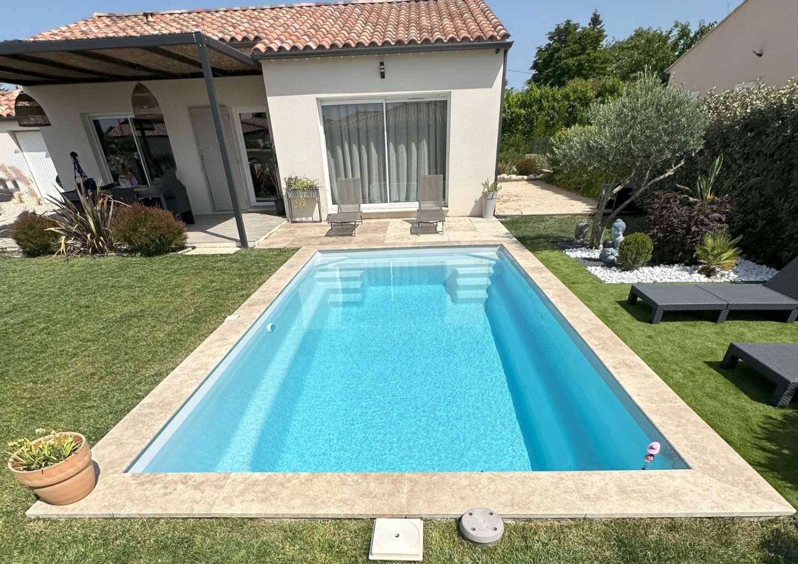 Piscine coque Sunshine 6,20 m posée à Barjols avec grande marche centrale.