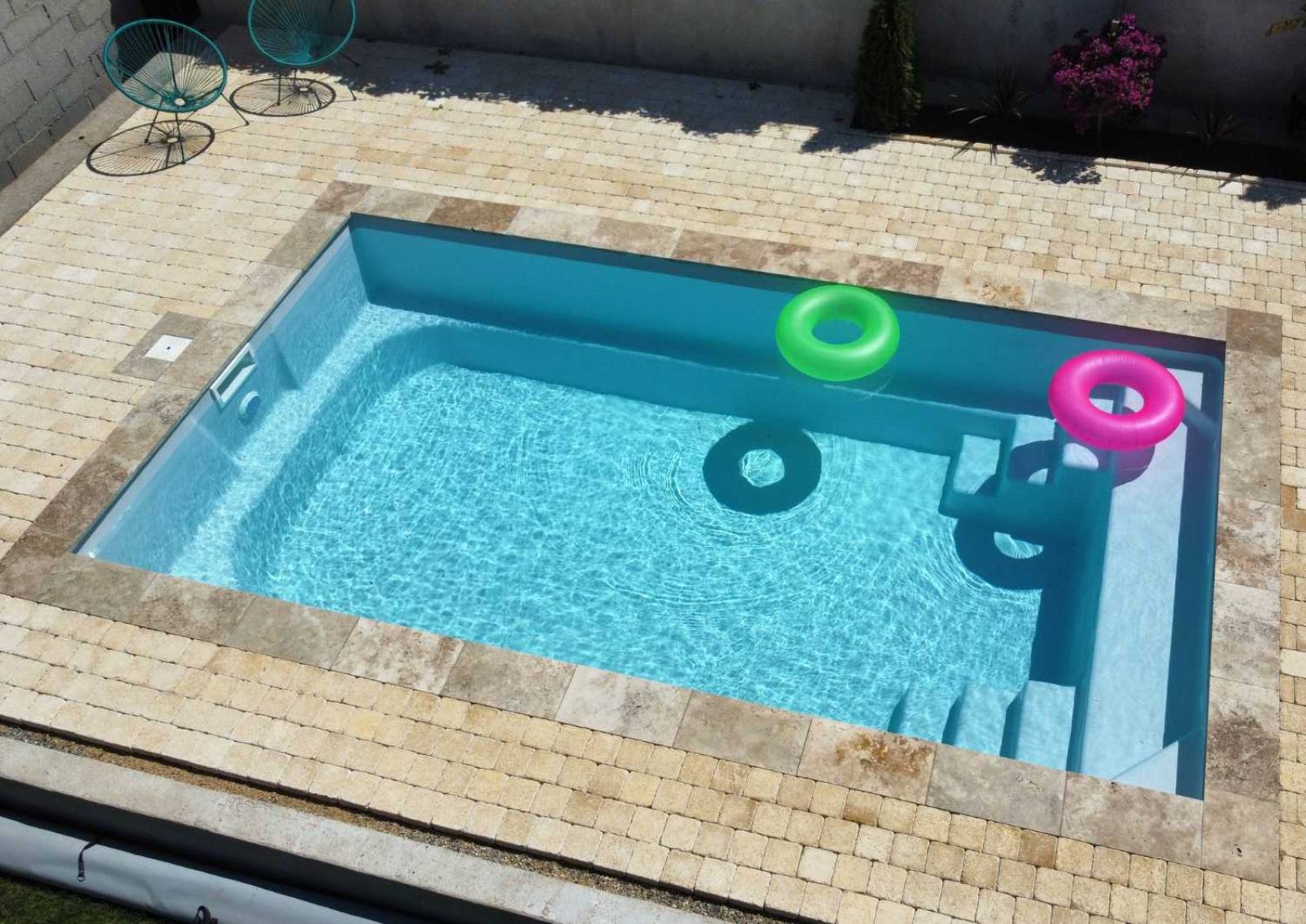 Piscine coque Sunshine 6,20 m posée à Barjols avec grande marche centrale.