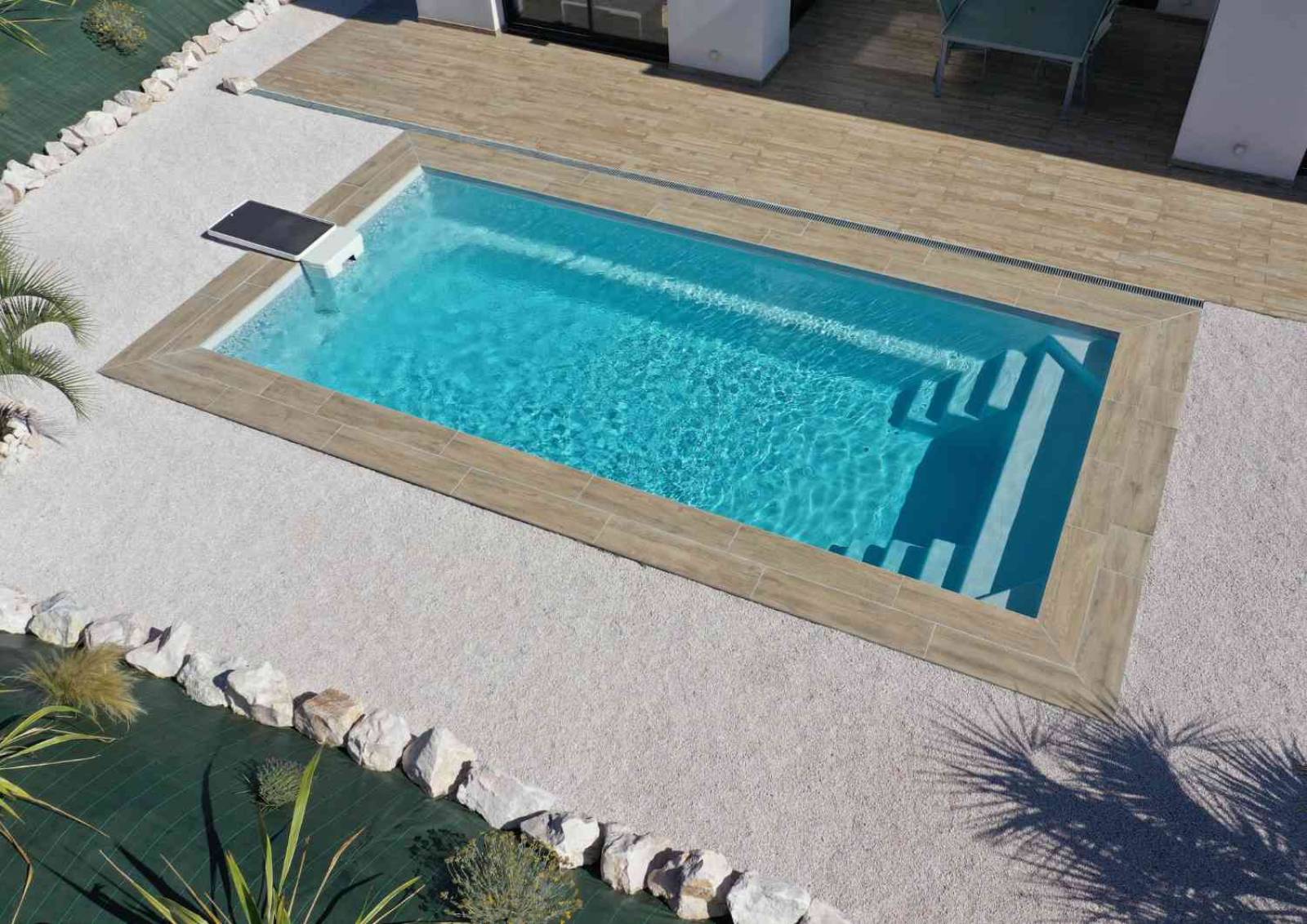 Piscine coque Shooter 8,20 m intégrée dans un jardin spacieux à Brignoles.