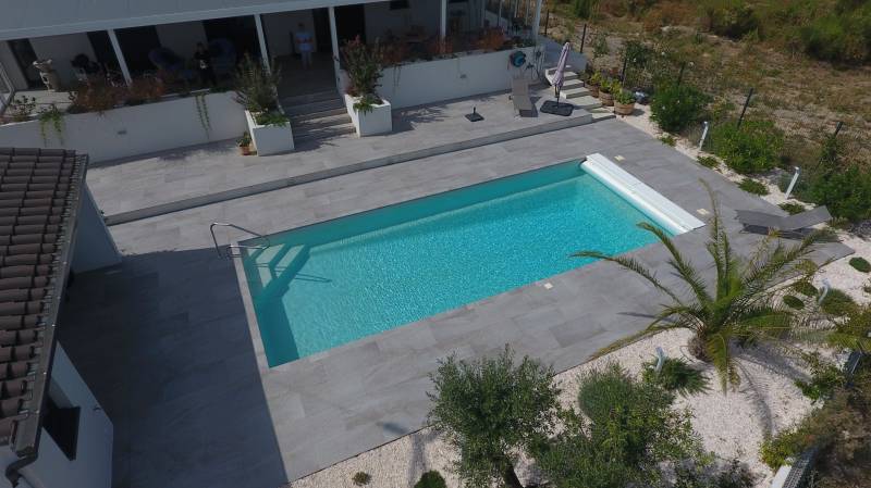 piscine coque cocktail avec plage beton et volet