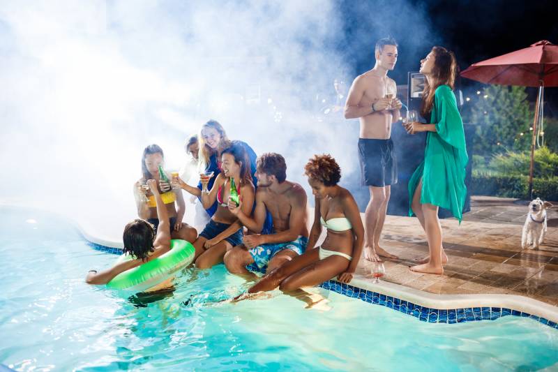 PISCINE chauffée qui fume avec des amis qui boiveent un cocktail