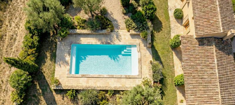 Piscine coque avec margelle dans jardin à Puget Ville
