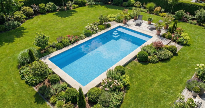 Piscine coque 8m dans jardin avec pelouse